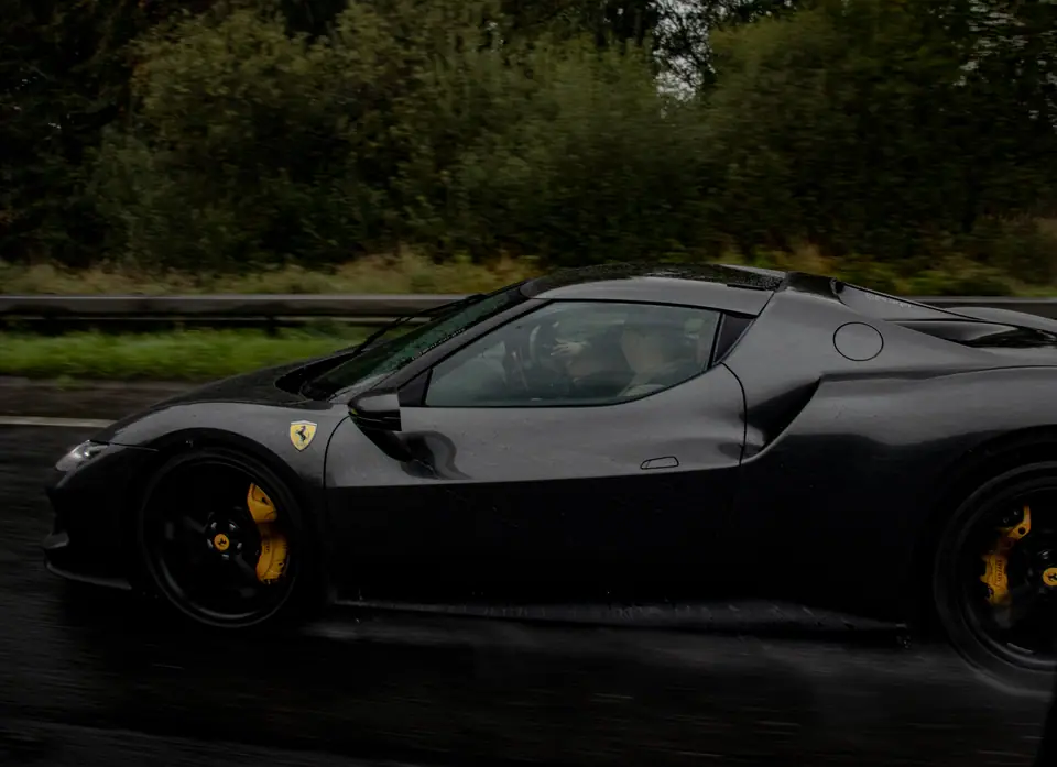 Black Ferrari SF90 at speed in the rain at Run 4 Eoin 2026